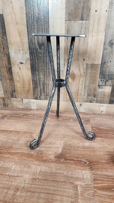 a small metal table on top of a wooden floor