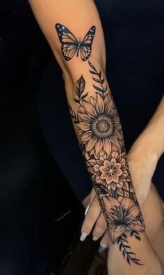 a woman's arm with sunflowers and butterflies on it