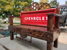 a bench made out of wood with the word chevrolet painted on it's back