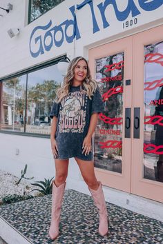 We have the cutest country graphic tees!! Style this tee several different ways such as with boots, shorts, and a bra tuck, or buy it oversized for a t-shirt dress with a rhinestone bodysuit underneath. Features a super soft cotton fabric, crew neck, boyfriend fit (loose in all the right places), black mineral wash base, Ombre graphics "Wild West Rodeo" in a western font, surrounding a bucking cowboy graphic. Fit: Runs true to size, model is wearing a medium. Approximate Measurements: Small- Bus Graphic Tee Cowboy Boots Outfit, Oversized T Shirt Cowboy Boots, Cowboy Boots Oversized Shirt, T Shirt Dress Cowboy Boots, T Shirt And Boots Outfit, Cowgirl Outfits Bachelorette Party, Tshirt Dress With Cowgirl Boots, Country Concert Outfit Oversized Tee