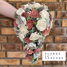 the bridal bouquet is being held up against a brick wall