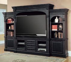 a large entertainment center with bookshelves and a flat screen tv mounted on the wall