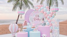 a baby shower is set up on the beach with balloons and teddy bears in pastel colors