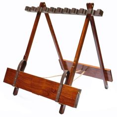 an old fashioned wooden frame with two straps on it's sides and one holding a piece of wood