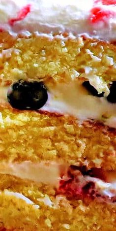 a close up view of a cake with blueberries and white frosting on it