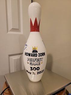 a white and red bowling ball sitting on top of a table