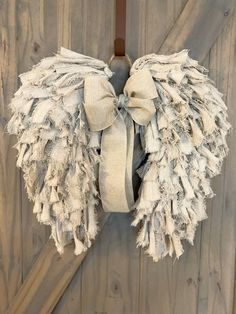 an angel wings wreath hanging on a wooden door