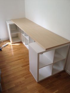 an empty room with white shelves and hard wood flooring