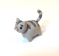 a gray cat figurine sitting on top of a white table