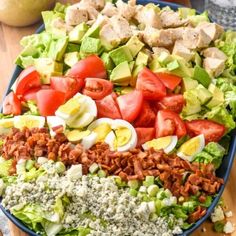 a large salad with hard boiled eggs, tomatoes, lettuce and other ingredients