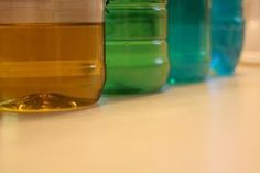 there are many different colored jars on the table together, one is filled with liquid