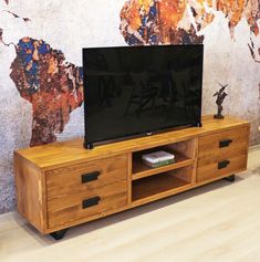 an entertainment center with a flat screen tv on it's stand in front of a painted wall