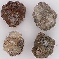 four different types of rocks on a white surface