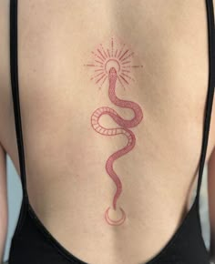 a woman's back with a snake tattoo on her left side ribcage