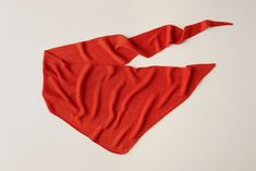 an orange scarf on a white surface with one piece cut out and the other part folded up