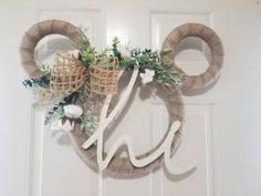 a mickey mouse wreath with the letter h on it's head is hanging on a door