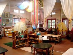 a room with tables, chairs and other items on display at the front of the room