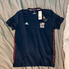 Nwt Adidas Olympic Games Usa Volleyball Navy Blue Short Sleeve Shirt. Unisex. Size S. Fabric Is Stretchy Workout Material. Adidas Sporty Tops For Sports Events, Adidas Letter Print Tops For Sports Events, Adidas Crew Neck Go-dry Tops, Adidas Tops With Letter Print For Sports Events, Adidas T-shirt For Sports Season Workouts, Blue Adidas Sportswear T-shirt, Adidas Graphic Print Workout T-shirt, Blue Adidas Tops For Sports Season, Volleyball Fits