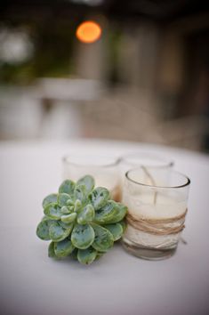 two small candles sitting on top of a white table