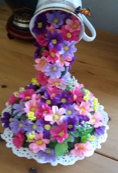 there is a cake made out of flowers on top of a doily with a hat on it