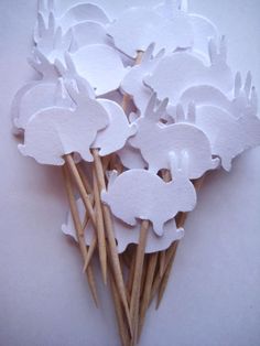 a bunch of white paper cutouts sitting on top of sticks