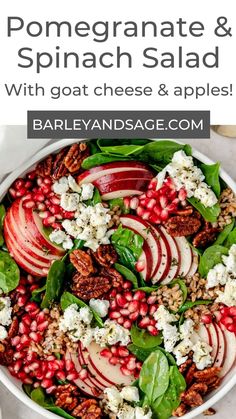 pomegranate and spinach salad with goat cheese & apples in a white bowl