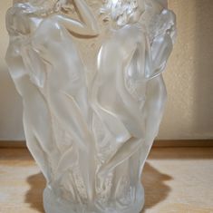 a white glass vase sitting on top of a wooden table