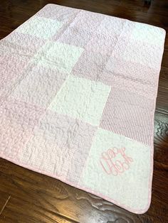 a pink and white quilted baby blanket with the word monogrammed on it