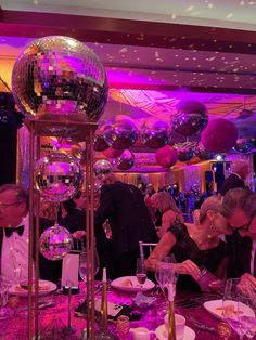 a group of people sitting at a table with disco balls