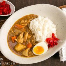 a white bowl filled with rice, meat and vegetables