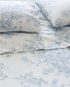 the blue and white bedding has flowers on it