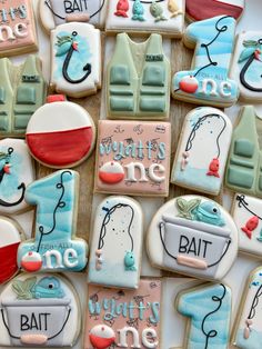 decorated cookies are arranged in the shape of boats and fishing related items with words on them