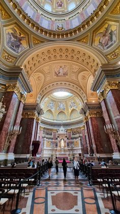 the inside of a church with people walking around