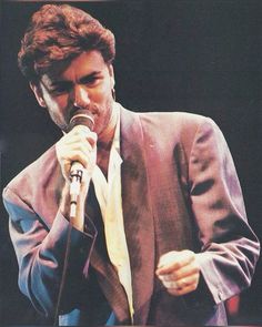 a man in a suit singing into a microphone