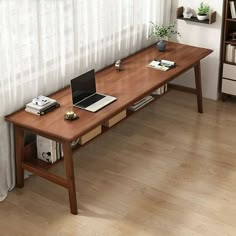 a wooden table with a laptop on top of it next to a book shelf and window