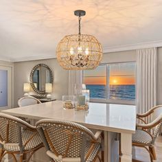 a dining room table with chairs and a chandelier hanging from it's ceiling