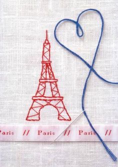 the eiffel tower is made out of paper and thread with a heart on it