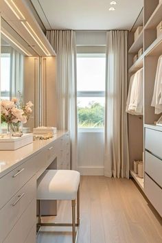 a walk - in closet with white cabinets and drawers, along with an open door leading to the outside