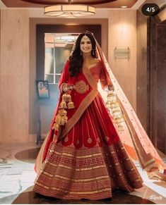 a woman in a red and gold bridal gown