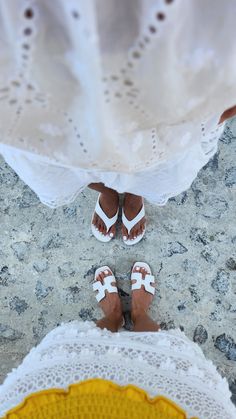 two people standing next to each other wearing sandals