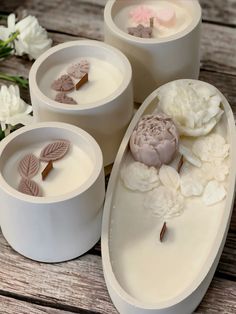 three candles with flowers in them sitting on a table