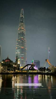 a very tall building towering over a city at night