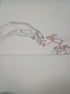 two hands touching each other with red string attached to the wall in front of them