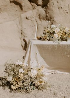 a table with flowers on it in the sand