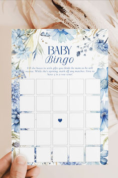 a baby shower game with blue flowers and feathers on the side, next to it