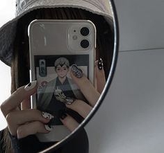 a woman taking a selfie in front of a mirror with her cell phone and hat on