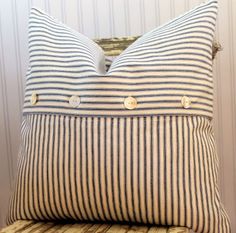 a striped pillow sitting on top of a wooden chair