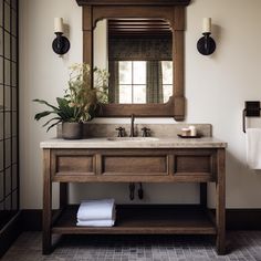 a bathroom sink with a mirror above it and towels on the counter next to it