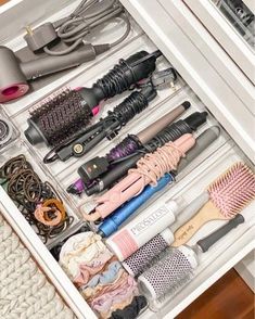 the drawer is filled with many different types of hair brushes