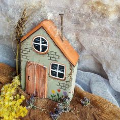 a small house made out of clay sitting on top of a burlap sack